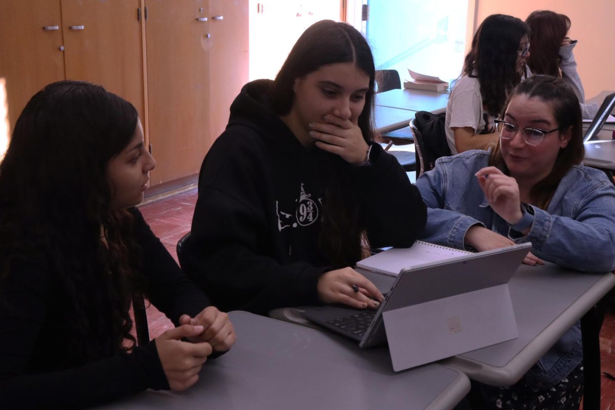 Freshman Abigail Macias and Junior Zarina Martirosyan discuss their writing assignment with Pierce College Professor Diamelys Perez during period one in Room 10 on Oct. 24.