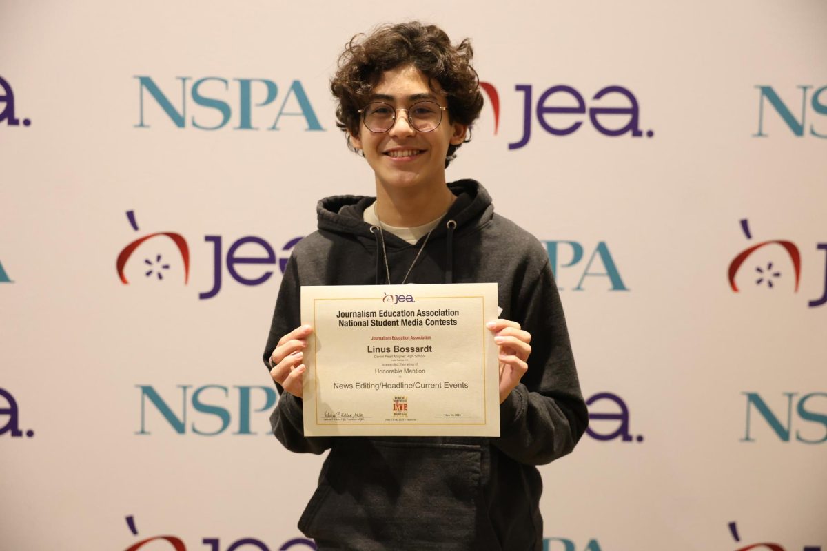 Managing Editor Linus Bossardt holds up his award for Honorable Mention in News Editing/Headline/Current Events National Student Media Contest on Nov. 16.