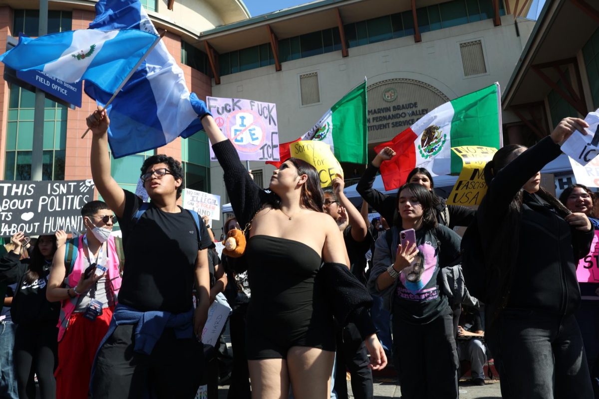 Senior Delilah Trujillo holds up a Salvadorian flag during the protest at Van Nuys City Hall on Feb. 6. 