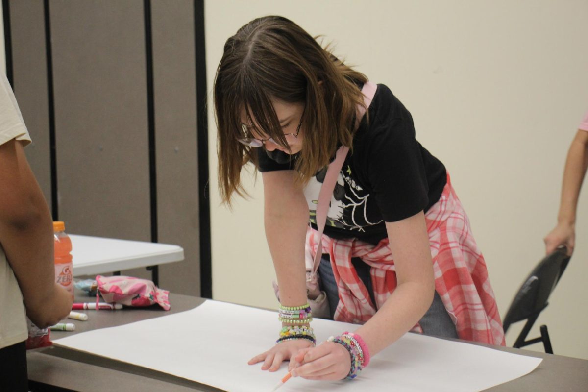 Freshman Sophia Torsoyan works on a poster during a school event at lunch intended to provide students the opportunity to express themselves in the MPR on Feb. 6. Daniel Pearl Magnet High School students walked out in protest of the killings and detentions in Minneapolis committed by Immigration and Customs Enforcement (ICE) agents. 