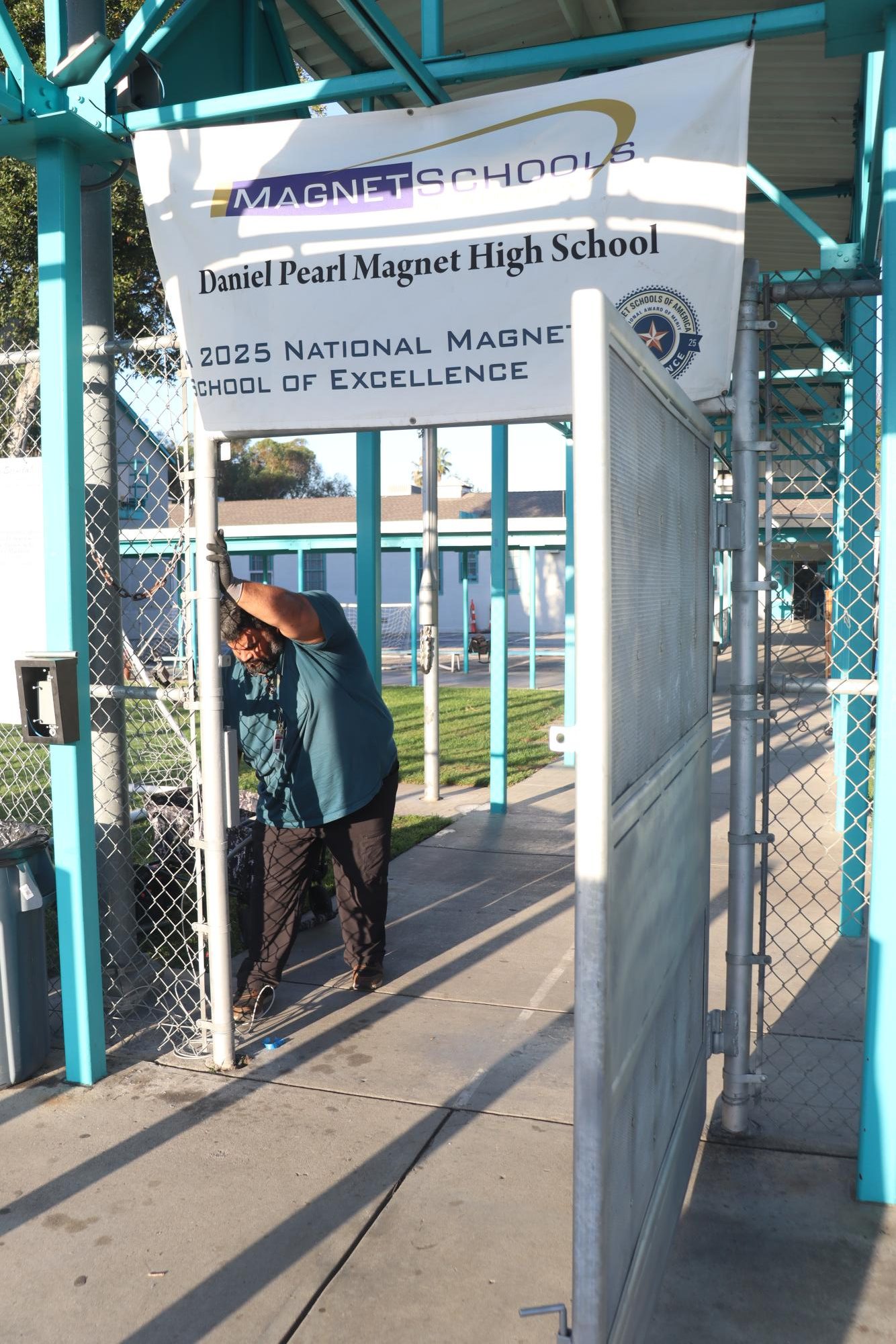 A Los Angeles Unified School District worker installs the new security gate in the front of the school on March 11.