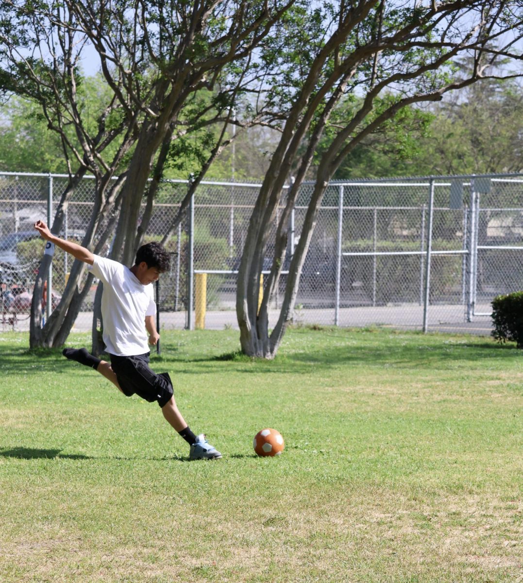 Sophomore Jefte Rodriguez kicks a soccer ball during the period 2 physical education (P.E.) class on Mar. 25. 