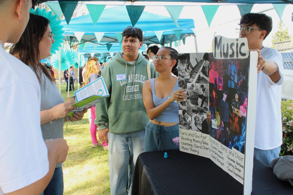 Guest parents speak to freshmen Axel Jimenez, Skyler Saji and junior Jesus Macias about the music department during Open House on March 13.