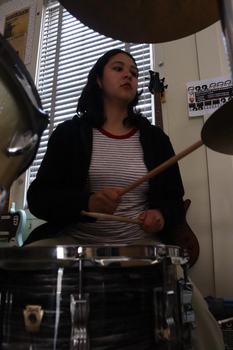 Senior Marianna Alvarez Patino plays drums for the song "Dark to Light," by Louis Tomlinson during lunch rehearsals for the Spring Concert on May 17.