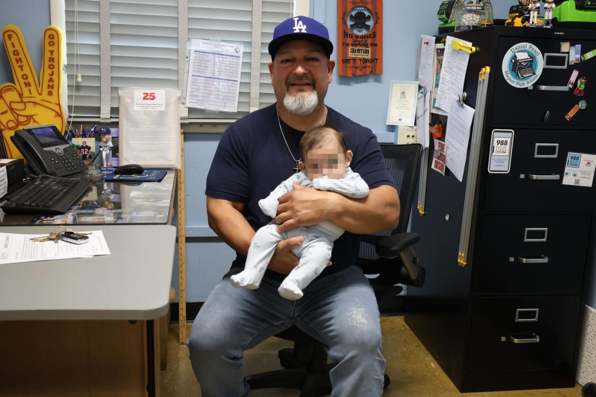Plant Manager Sal Rivas with the baby he was fostering in his office on April 23. Rivas has been fostering children with his wife after learning about it from his church. The baby's face is pixellated to protect their privacy.